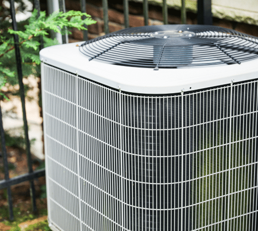 Outdoor air conditioning unit near metal fence
